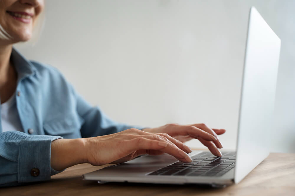 Especialista em consultoria de Google Ads mexendo no notebook.