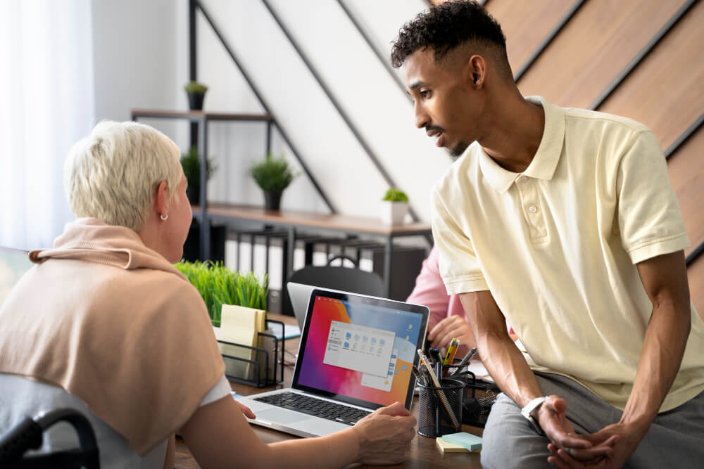 Homem auxiliando mulher com o uso de conteúdos mais inclusivos.